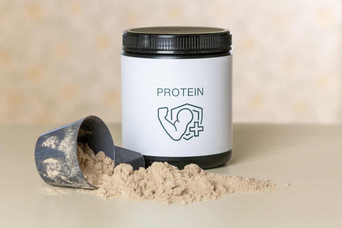 Protein powder container with a scoop of powder for shakes